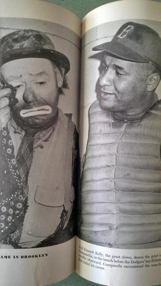 "Emmett Kelly, the great clown, shares the grief of the moment with Roy Campanella, on the bench before the Dodgers' last Ebbets Field appearance.  Short months afterward, Campanella encountered the near-fatal automobile accident that ended his career".